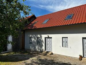 a white building with a red roof at Barn House in Ptuj