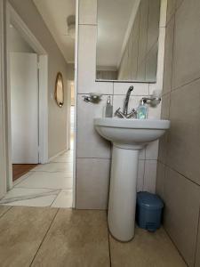 a bathroom with a white sink and a mirror at T&A Escape in Grassy Park +20 photos