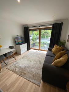 a living room with a couch and a table and a television at Apt 2 Cathedral & River view in Norwich