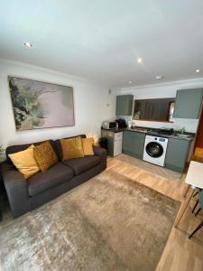 a living room with a couch and a kitchen at Apt 2 Cathedral & River view in Norwich