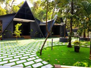 a house with a tree in the middle of a yard at Creek Cottage in Kollam