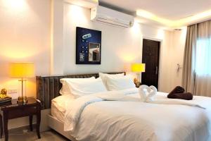 a bedroom with a large white bed with two white towels at Varaya Resort in Ban Kraek
