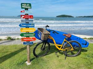 a bike parked next to a street sign with a surfboard at Pousada Ilha Vitoria in Ubatuba +57 photos