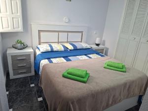 a bedroom with two beds with green towels on them at Casas Holiday - Puerto Romano in La Mata +23 photos