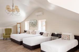a room with three beds and a chair at Suites Guest House in Cascais