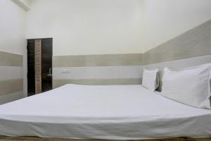 a bedroom with a large bed with white sheets and pillows at Hotel O The Starlight in Ghaziabad