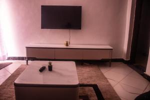 a living room with a table and a flat screen tv at Cisa Homes in Gatunga