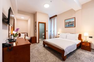 a hotel room with a bed and a desk at Hotel Montenegrino in Tivat