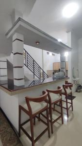 a living room with two chairs and a kitchen at UnitA 5BR Kangen Homestay Jambon Yogyakarta in Cebongan