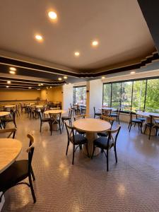 a dining room with tables and chairs and windows at Nigrum Hotel Nevsehir Cappadocia in Nevşehir