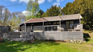 a wooden house with chairs in the yard at Haus Hav in Ronneby