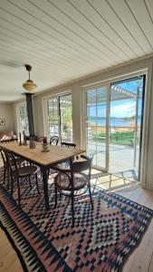 a dining room with a table and chairs on a rug at Haus Hav in Ronneby