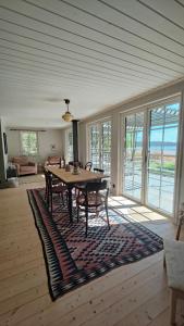 a dining room with a table and chairs on a rug at Haus Hav in Ronneby +24 photos