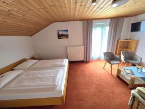 a bedroom with a bed and a table and a chair at Pension Speckmoser in Bad Mitterndorf +34 photos