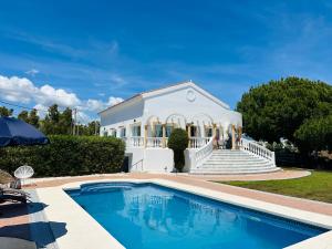 a house with a swimming pool in front of a building at Villa El Dorado in Estepona