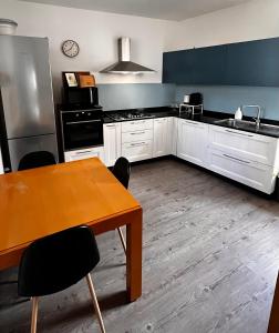 a kitchen with white cabinets and a wooden table at Casa Stella in Venzone