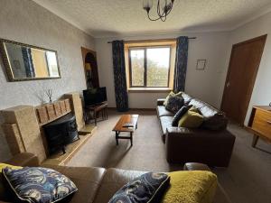 a living room with a couch and a television at Taigh Na Casag in Lionel