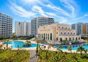 a building with two pools in front of some buildings at Caesar Resort & Spa Collection Studios Pools & Long Beach in Iskele