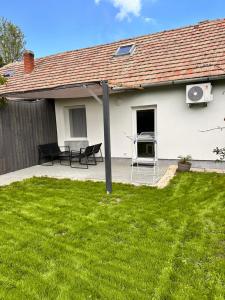 a patio with a table and chairs in a yard at Vendégház Alsóörs in Alsóörs
