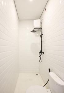 a white bathroom with a toilet and a shower at Elia's House renovated in Canggu
