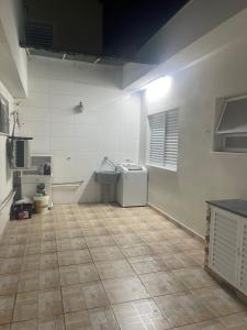a kitchen with a tile floor and a sink at Casa aconchegante centro in Peruíbe