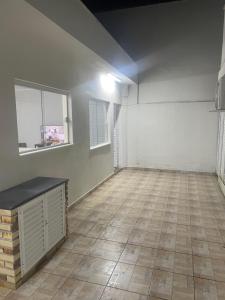 an empty room with white walls and a tile floor at Casa aconchegante centro in Peruíbe