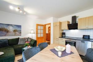 a kitchen and living room with a table and a couch at Ferien- und Pferdehof Egelkraut "Feriendomizil am Meer" in Wangerland