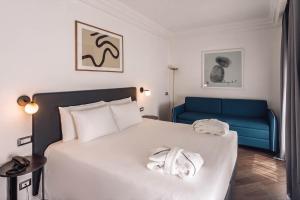 a bedroom with a bed and a blue couch at BB Hotels Smarthotel Missori in Milan