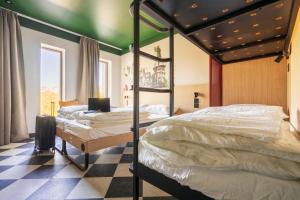 two beds in a room with a checkered floor at MEININGER Hotel Edinburgh Haymarket in Edinburgh
