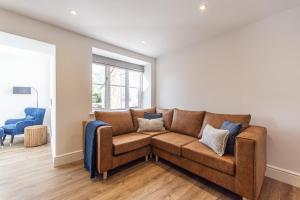 a living room with a brown couch and a window at Stretton Lower hall in Malpas +25 photos