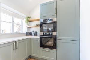 a kitchen with white cabinets and an oven at Stretton Lower hall in Malpas