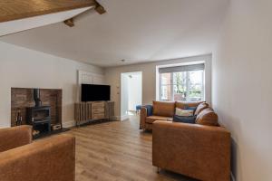 a living room with two couches and a television at Stretton Lower hall in Malpas