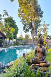 a statue of a buddha in front of a pool at Varaya Resort in Ban Kraek +104 photos