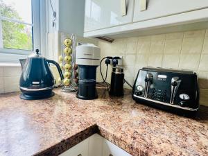 a kitchen counter with a toaster and a blender on it at The Priory Cottage in Legbourne