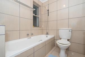 a bathroom with a toilet and a tub and a sink at Seabreeze Bungalow in Langebaan