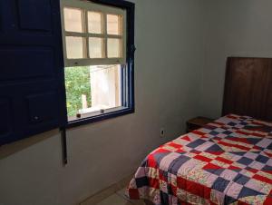 a bedroom with a bed and a window at Casa da tranquilidade in Ouro Preto