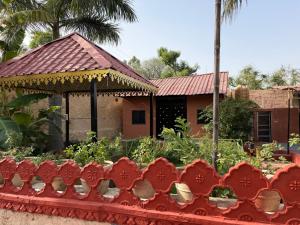 a garden in front of a house with a roof at The Udaikot farm in Rāma +11 photos
