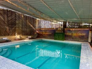 a large swimming pool with blue water in a room at The Udaikot farm in Rāma