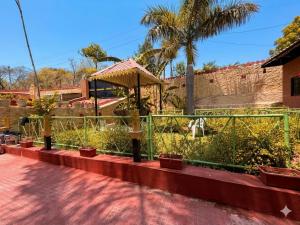 a garden with potted plants and a fence at The Udaikot farm in Rāma