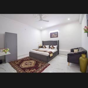 a bedroom with a bed and a couch and a chair at The Udaikot farm in Rāma