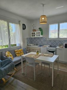 a living room with a table and a kitchen at Partie de villa in Velleron