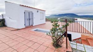 a white house with a balcony with a plant at AT El Cordel in Nogales