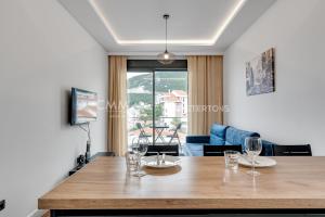 a dining room with a table with wine glasses on it at Elia Suites in Bečići