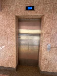 a elevator door in a building with a clock on it at Makenahluxuries Embu Paradise Apartment near Java Gakwegori in Kangaru