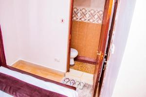 a small bathroom with a toilet and a mirror at Makenahluxuries Embu Paradise Apartment near Java Gakwegori in Kangaru +9 photos