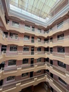 an empty building with balconies and a glass ceiling at Makenahluxuries Embu Paradise Apartment near Java Gakwegori in Kangaru