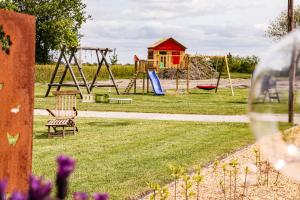 a park with a playground with a swing at Ferien- und Pferdehof Egelkraut "Feriendomizil am Meer" in Wangerland