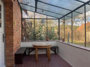a patio with a wooden table in front of a window at Haus Prälank in Neustrelitz
