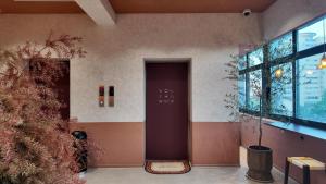 a hallway with a door and a plant in a building at 無桐Mini酒店WowTown in Shanghai