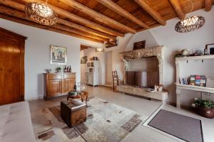 a large living room with a fireplace and wooden ceilings at Corte Lavarini in Fumane